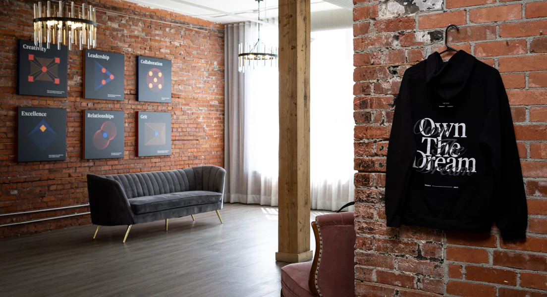 black hoodie with "Own the Dream" on the back